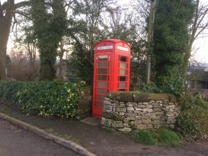 An old style red phone box containing the village defibrillator.