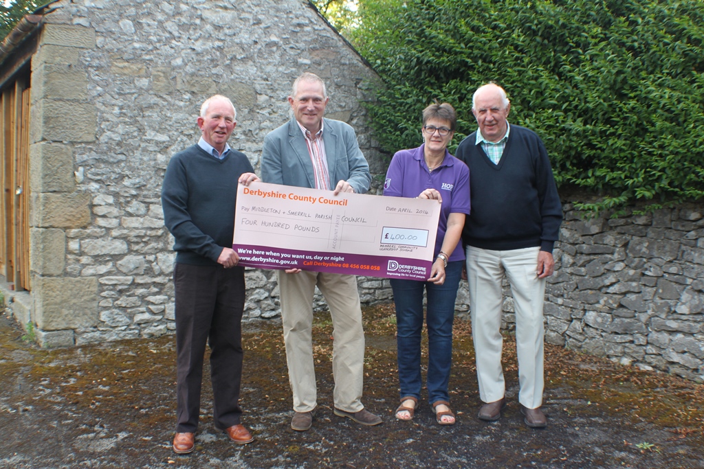 A picture of three smiling men and one woman holding a cheque for £400  from Derbyshire County Council to the parish council.